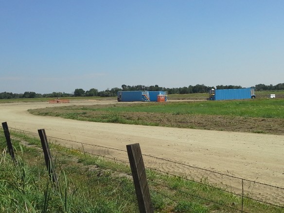 Protesters observe the capped well head and pad at the Smoke Ranch site south of Highway 52, the first directionally drilled natural gas well in the state, located in a floodplain full of standing water, wetlands, irrigation canals, riparian areas, and a wildlife refuge, between the Payette River and Big Willow Creek, only a few miles upstream from the City of Fruitland municipal water intake and the Payette/Snake River confluence.