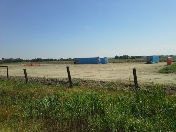 Protesters observe the capped well head and pad at the Smoke Ranch site south of Highway 52, the first directionally drilled natural gas well in the state, located in a floodplain full of standing water, wetlands, irrigation canals, riparian areas, and a wildlife refuge, between the Payette River and Big Willow Creek, only a few miles upstream from the City of Fruitland municipal water intake and the Payette/Snake River confluence.